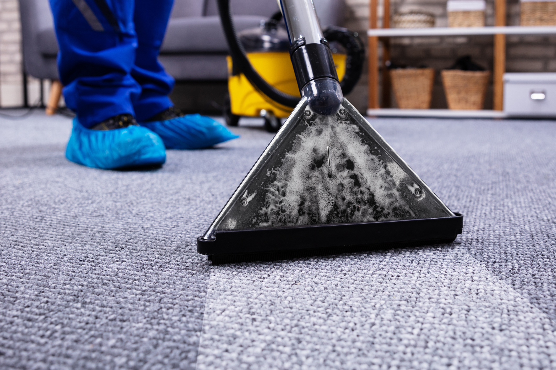 Person Cleaning Carpet With Vacuum Cleaner