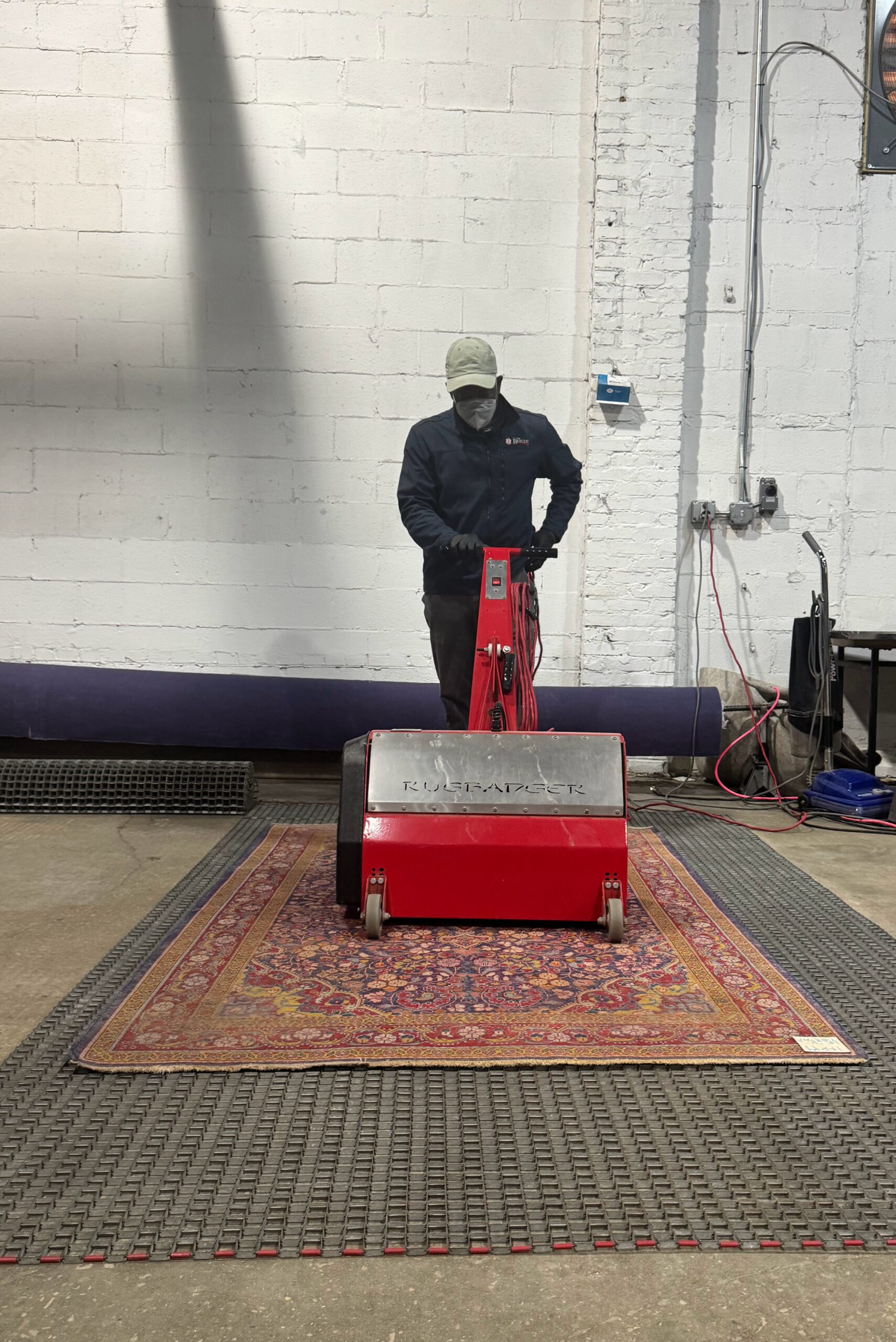 This photo shows Lorrin using a rug bagger to perform dry soil removal on a heavily trafficked rug.